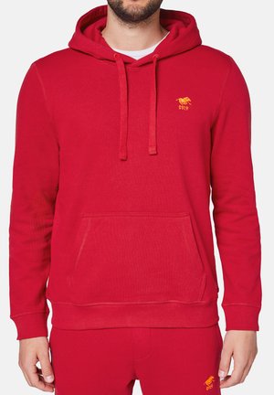Roter Baumwoll-Hoodie mit Kängurutasche, Kordelzügen, gerippten Bündchen und Saum. Verfügt über ein kleines gelbes Logo auf der Brust. weiche Textur.