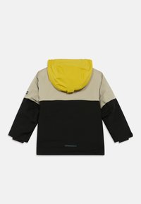 Bērnu krāsaini blokota jakas apakšdaļa melnā krāsā, augšdaļa bēša krāsā un dzeltena kapuce, attēlota no aizmugures.