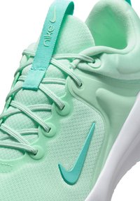Nike tenisice u mint zelenoj boji s teksturiranim mrežastim gornjim dijelom, glatkim gumenim detaljima i bijelim međuslojem. Imaju ravni sustav vezanja i logo.