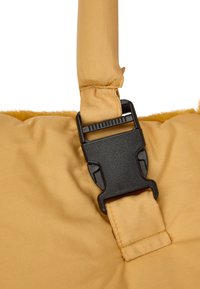Yellow fabric bag with a soft texture. Features a black plastic buckle and strap. Simple design with a smooth finish and stitched detailing.