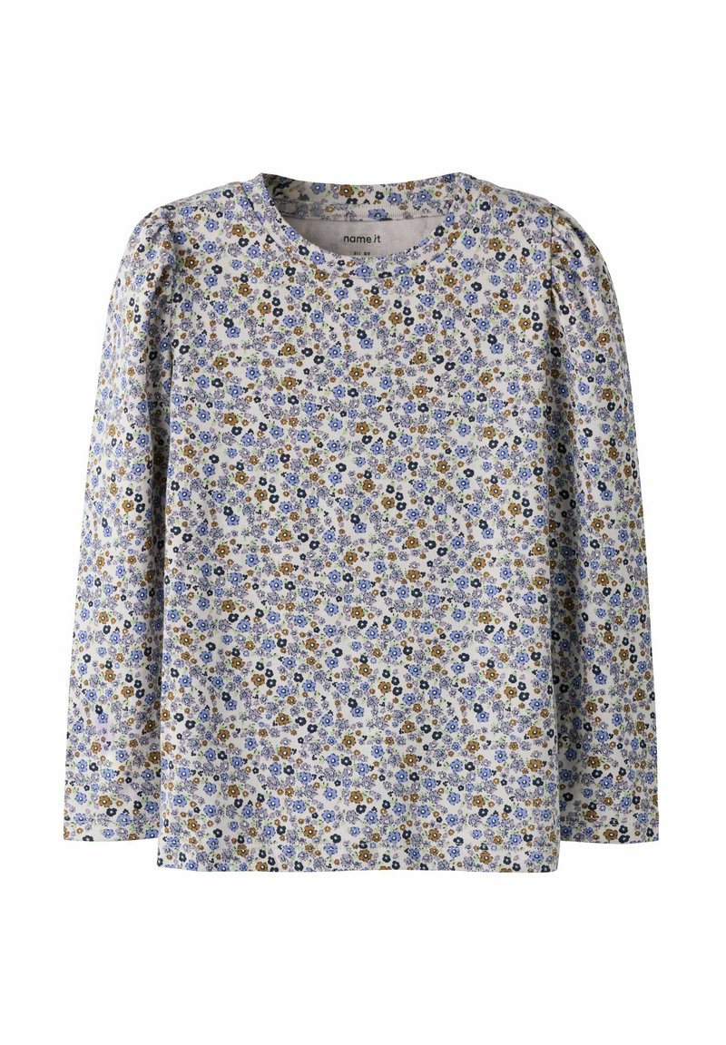 Kinderbloes met lange mouwen en een dicht patroon van kleine blauwe, gele en zwarte bloemen op een lichte achtergrond.