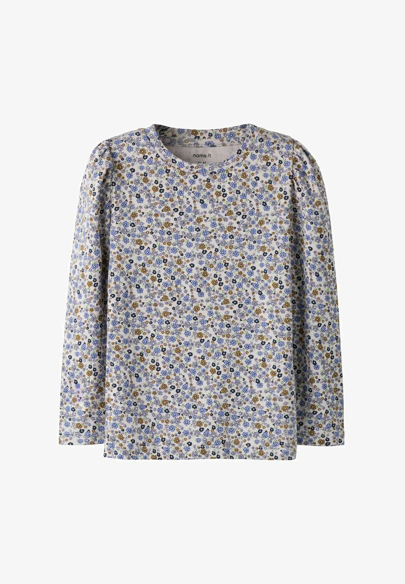 Kinderbloes met lange mouwen en een dicht patroon van kleine blauwe, gele en zwarte bloemen op een lichte achtergrond.