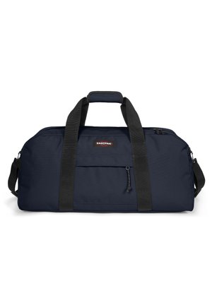 Sac de sport marine en tissu durable. Doté de poignées noires, d'une fermeture éclair et d'une poche avant avec un petit tirette.