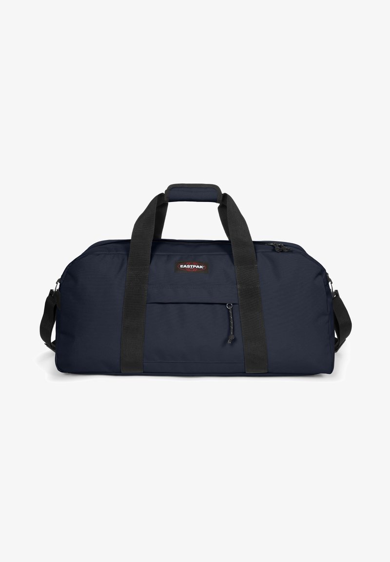Sac de sport marine en tissu durable. Doté de poignées noires, d'une fermeture éclair et d'une poche avant avec un petit tirette.