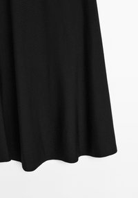 Black, ribbed fabric with a smooth, flowing texture. The design features an A-line shape that drapes gently towards the hem.