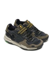 Sneakers neri e grigi con tomaia in pelle testurizzata, intersuola in schiuma maculata, dettagli verdi e lacci neri. Dettaglio del logo laterale notevole.