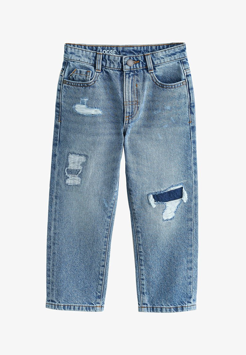 Jean bleu en denim coupe ample avec des patchs usés sur la cuisse gauche, le genou droit et une petite zone effilochée sur la poche gauche.
