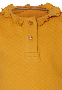 Żółty materiał o fakturze z falbaniastym kołnierzykiem, z dwoma brązowymi guzikami i paskowanym wnętrzem dekoltu.