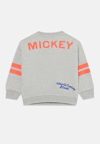 Ljusgrå sweatshirt med röd "MICKEY" text över den övre ryggen, två röda ränder på varje ärm och blå "Mickey Mouse" text nära nederkanten.