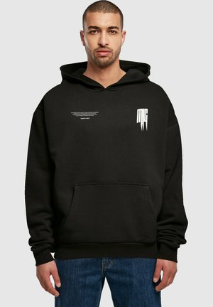 Zwarte hoodie van zachte stof, met een voorklep en witte tekst- en logoaccenten op de borst.