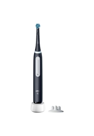 Brosse à dents électrique avec tête de brosse ronde rotative sur un support de charge, à côté d'un petit accessoire blanc avec trois pointes arrondies.