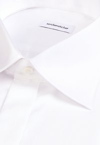 Chemise blanche avec col à la française et une étiquette intérieure visible portant la mention « seidensticker ».