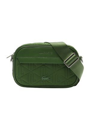 Grüne rechteckige Umhängetasche mit verstellbarem Riemen, geprägtem geometrischem Muster, Lacoste-Logo und Reißverschluss.