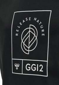 Sort t-shirt med et hvidt grafisk design, der har teksten "RELEASE NATURE" og et geometrisk bladmønster, samt "GGI2" og et bi-symbol.