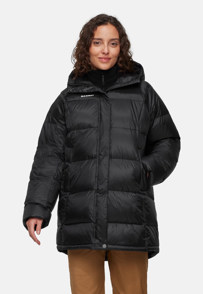 Sort puffer-jakke med hætte, der har et quiltet design, en høj krave og lynlåslommer. Materialet ser blankt og isoleret ud.