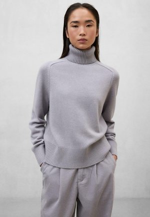 Suéter de cuello alto gris claro con dobladillo y puños acanalados, hecho de material suave, combinado con pantalones texturizados a juego.