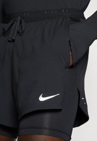 Schwarze Nike-Laufshorts mit glatter Textur, elastischem Bund, Kordelzug und einem weißen Nike-Logo auf der linken Unterseite.