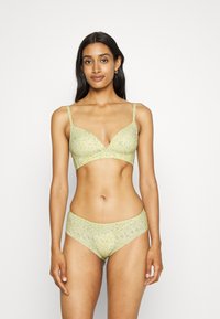 Conjunto de sutiã e cuecas com padrão floral em verde-claro, apresentando tecido suave, finas alças ajustáveis e um acabamento liso.