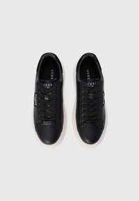 Black leather sneakers with round toe, black laces, and white rubber sole. Features a logo on the side and branding on the tongue.