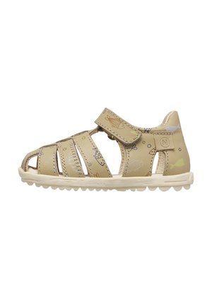 Beige children's sandal with fish pattern, closed heel, adjustable Velcro strap, and white rubber sole with grip.