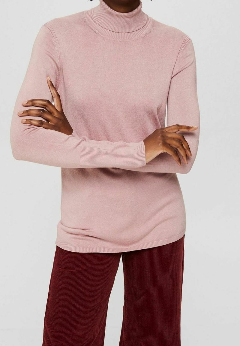 Jasnoróżowy golf z miękkiej tkaniny, z pr�ążkowanymi mankietami i dopasowanym fasonem. Noszony z bordowymi sztruksowymi spodniami.