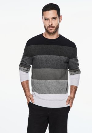 Sweter z dzianiny w poziome paski w kolorach czarnym, ciemnoszarym, średnioszarym, jasnoszarym i białym. Wyposażony w okrągły dekolt i ściągacze przy mankietach.