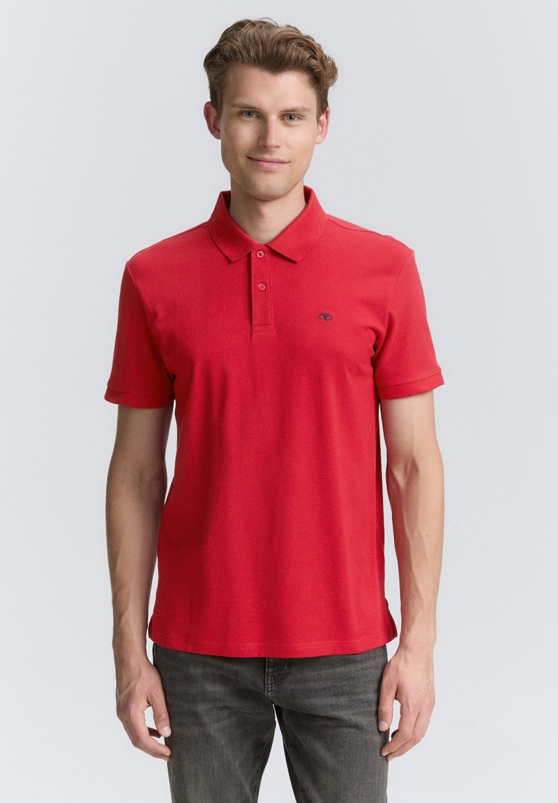 Rød polo shirt med krave og tre-knaps placket, lavet af bomuld. Har korte ærmer og et lille logo på brystet.