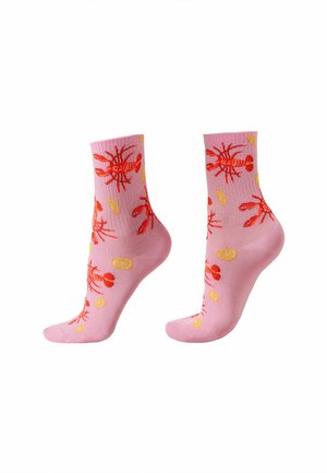 Calzini alla caviglia rosa con motivi di aragoste rosse e fette di limone gialle, mostrati fianco a fianco su uno sfondo bianco.