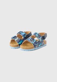 Sandálias de cortiça com padrão de camuflagem azul e verde, tiras ajustáveis e solas de borracha azul claro. Design plano com biqueira aberta.