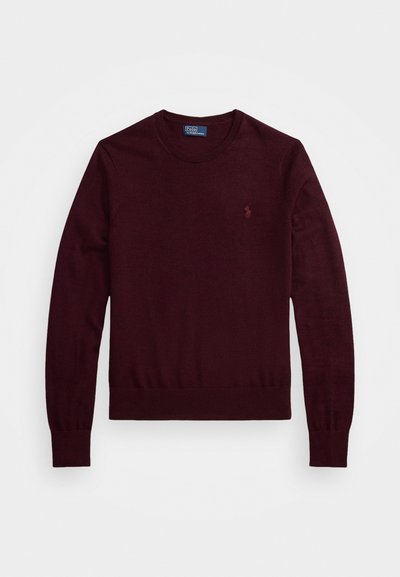Pull bordeaux à col rond, à manches longues et avec un ourlet côtelé. Présente un petit logo brodé sur la poitrine, fabriqué en matériau doux.