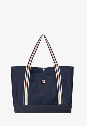 Bolsa tote azul marino con bolsillo delantero, cierre de botón y largas correas blancas con rayas rojas y azul marino.