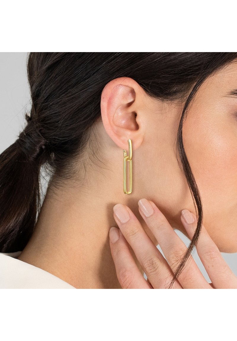 Zlato obarvane viseče uhane odlikuje podolgovata, pravokotna oblika z gladko, polirano obdelavo. Oblikovanje vključuje majhen obroček za pritrditev.