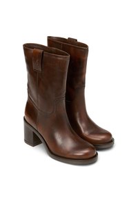 Bruine leren enkellaarsjes met een gladde afwerking, ronde neus en een blokhak. Voorzien van een logo-accent op de schacht en stiksels.