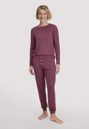 Bordeauxfarbenes Loungewear-Set mit einem langärmligen Oberteil und einer Hose mit elastischem Bund und Knopfakzenten an der Hose. Weicher Stoff.
