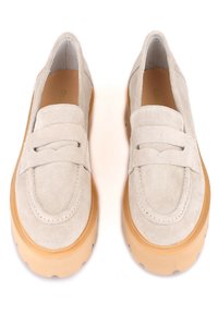 Mocassins en daim gris clair avec un bout arrondi, dotés d'une lanière décorative et d'une semelle en caoutchouc épaisse de couleur marron clair pour un confort accru.