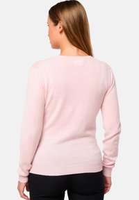 Pull long à manches longues rose clair en tissu doux, avec un col rond et des poignets et ourlet en côtes, et un design sans couture aux épaules.