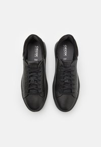 Sneakers in pelle nera con superficie testurizzata, punta tonda e chiusura con lacci. Dotati di suole interne ammortizzate e design minimalista.