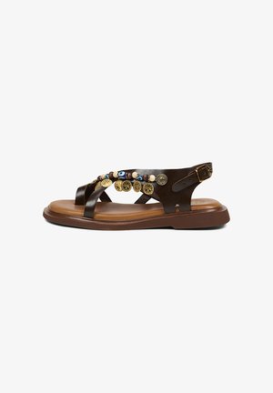 Bruine leren platte sandaal met enkelriem, versierd met gouden munten en meerkleurige kralen op de bovenste bandjes, zijaanzicht.