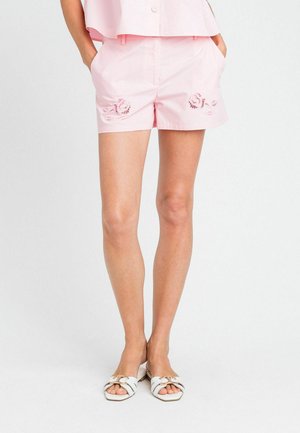 Pantaloni corti di cotone rosa con tasche laterali, caratterizzati da motivi di conchiglie ricamati sul davanti. Texture liscia e vestibilità su misura.