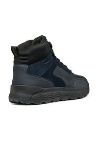 Wysokie sneakersy z ciemnoniebieskiej skóry i zamszu, z czarnym, wypełnionym kołnierzem i teksturowaną gumową podeszwą. Posiadają okrągłe sznurówki oraz boczne akcenty.