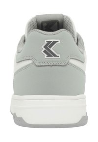 Pogled od zadaj sive in bele superge z oblazinjeno ovratnico in črnim stiliziranim logotipom "K" na jezičku pete.