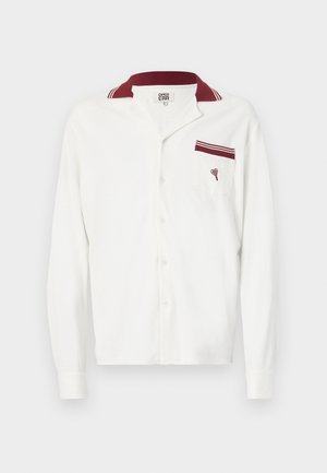 Camisa blanca de manga larga con una tela texturizada, cuello burdeos y un bolsillo con un acento burdeos y un diseño bordado.