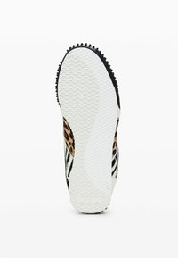 Zapatilla con suela de goma negra texturizada y un patrón ondulado blanco. La parte superior presenta un estampado de leopardo y rayas en blanco y negro.