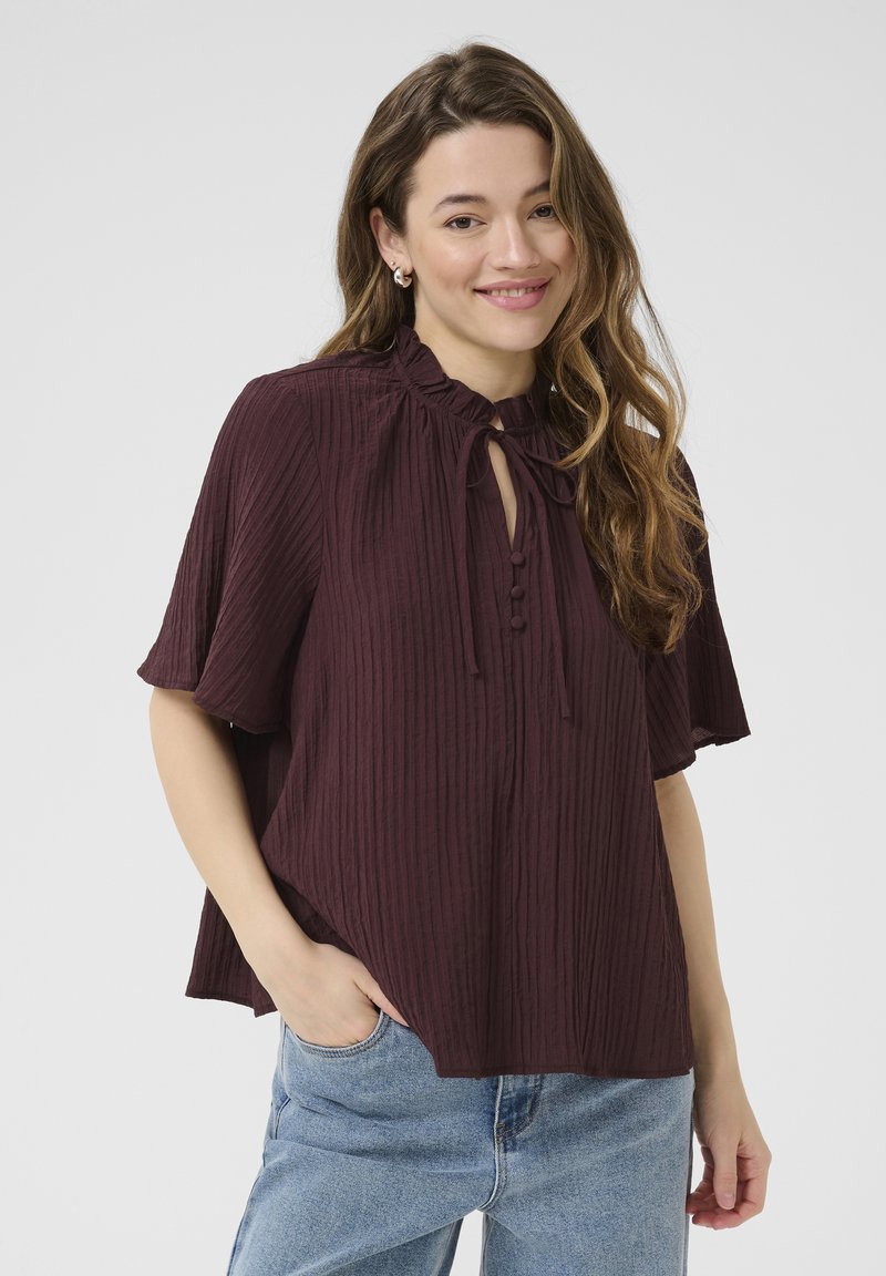 Bordeaux gestreepte blouse met een gerimpelde halslijn, knoopdetails en korte mouwen. De stof lijkt lichtgewicht met een zachte textuur.
