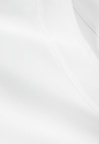 White fabric with a smooth texture and subtle sheen. Features a v-neckline with clean stitching. No visible patterns or accents.