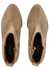 Stivali ankle in suede marrone con punta a punta e zip laterale. Texture morbida, design minimalista, con tacco basso impilato.