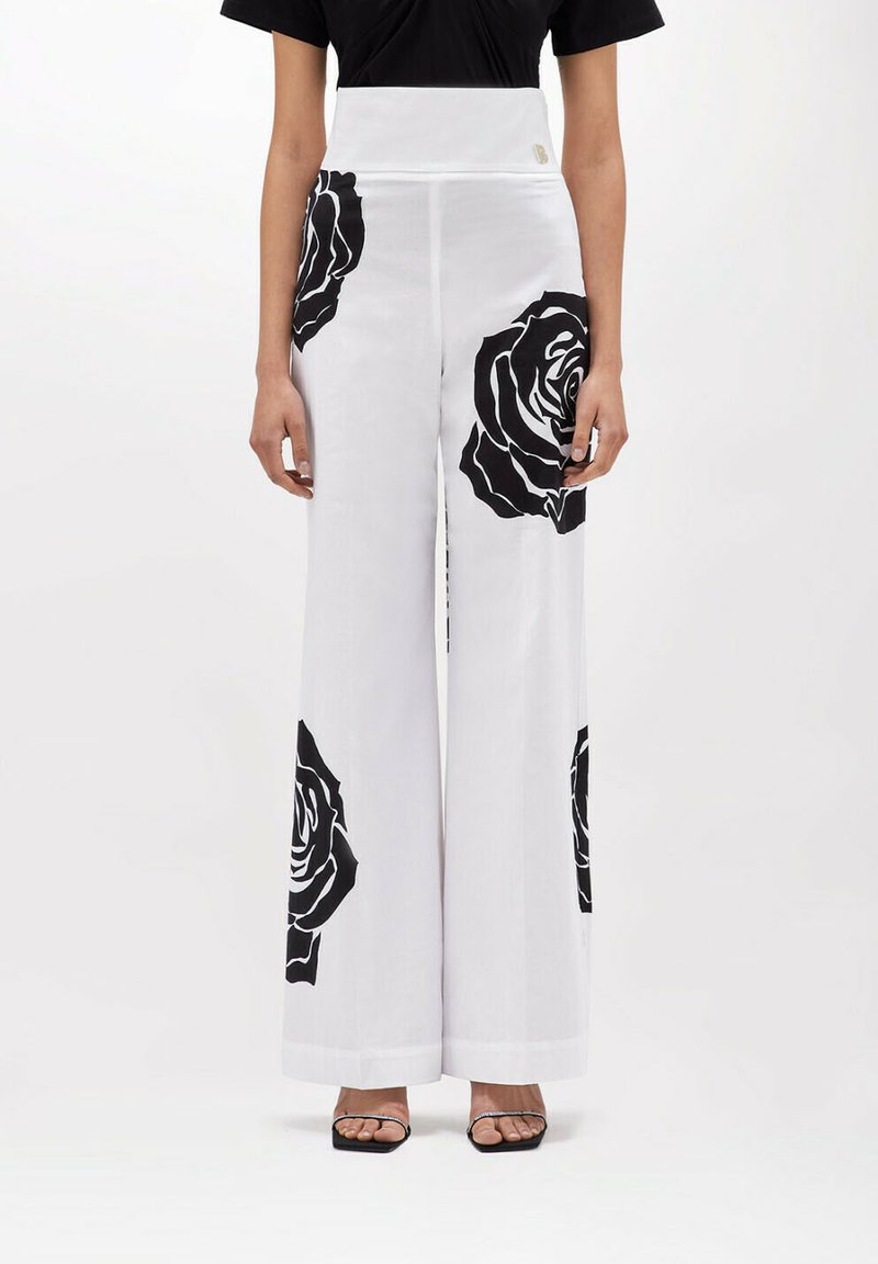 Pantaloni bianchi a gamba larga con grandi stampe di rose nere, design a vita alta, realizzati in tessuto leggero, con zip laterale nascosta.
