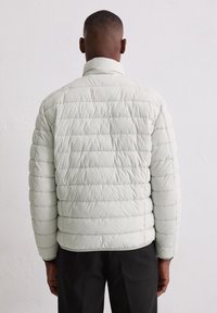 Jasnoszara kurtka puchowa z poziomymi przeszyciami, wysokim kołnierzem i elastycznymi mankietami, o gładkim, błyszczącym wykończeniu.