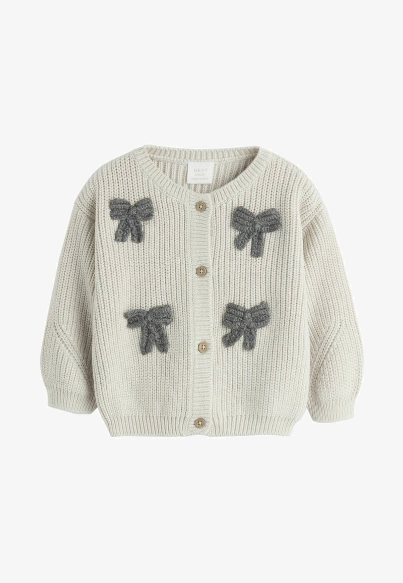 Lys beige strikket cardigan med grå sløjfeapplikationer, der har en rund halsudskæring, knaplukning foran og ribstrikkede manchetter.