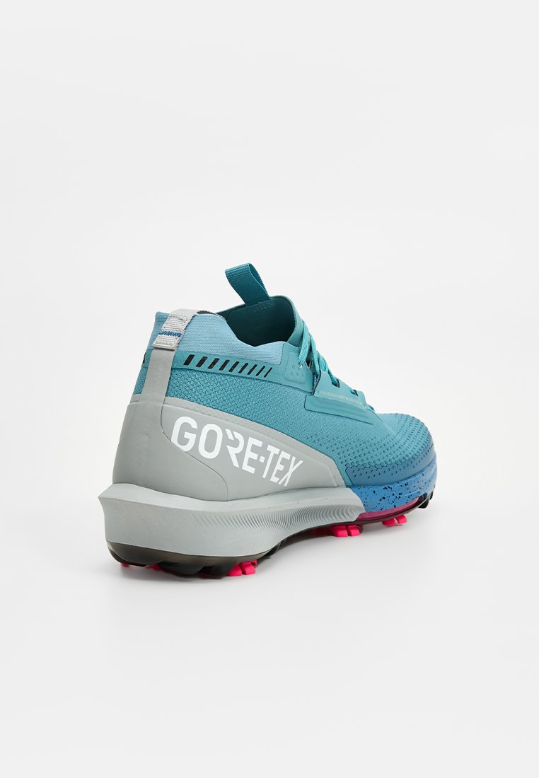 Wodoodporne buty do biegania w kolorze szmaragdowym i szarym, z teksturowaną cholewką, logo GORE-TEX po boku i różową gumową podeszwą dla lepszej przyczepności.